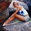 Female Model in Shorts and Knit Summer Shirt Sitting on Granite Rocks