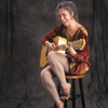Maggie Simpson, Laughing, with Her Guitar for a Promotional Shot